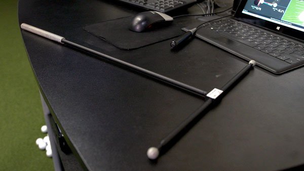 The t-shaped wand used for marker calibration sits on a desk next to a computer